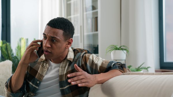 man talking on phone appearing annoyed